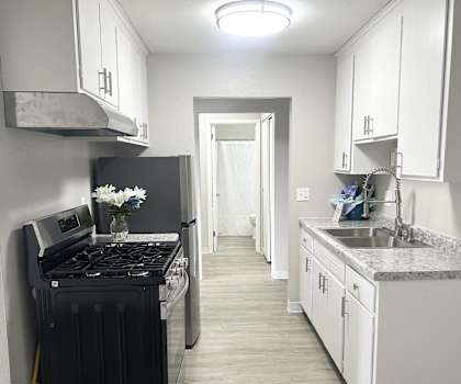 a kitchen with white cabinets and a black stove
