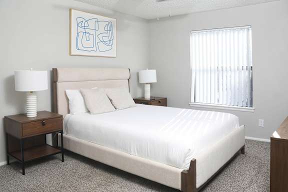 a bedroom with a large white bed and a window