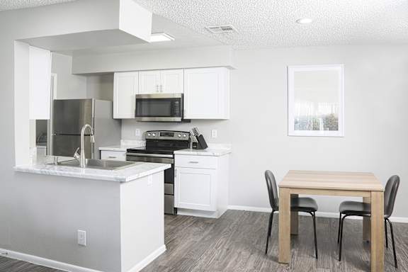 a kitchen and dining room with a table and chairs