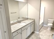 Thumbnail 12 of 60 - B1 (1-car) Master Bath with tile flooring, granite countertops, and sink