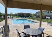 Thumbnail 4 of 60 - Community Pool and patio with table and chairs