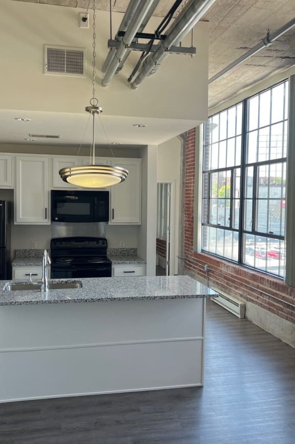 an open kitchen with a large window and a counter top in front of a kitchen