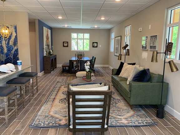 A living room with a green couch and a rug.