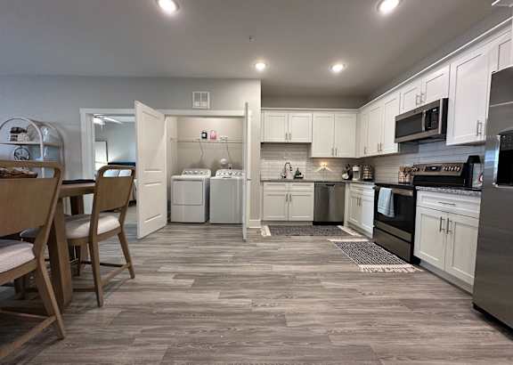 A kitchen with a dining table and chairs.