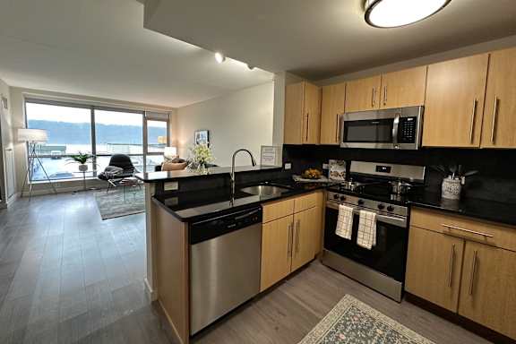 A kitchen with wooden cabinets and black countertops.