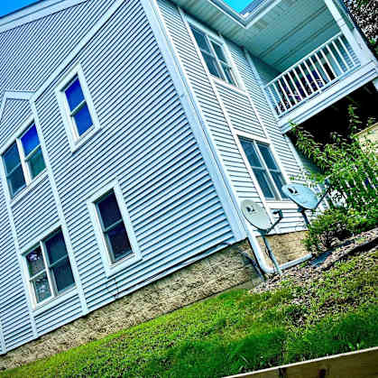 A house with a blue siding and a white balcony.