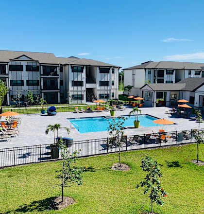 an aerial view of a swimming pool with apartments in the background