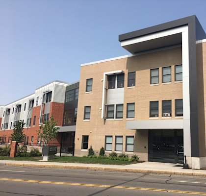 A modern building with a mix of brick and panel construction.
