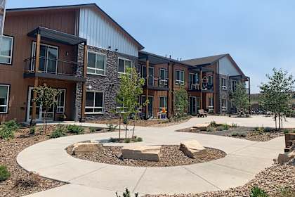an exterior view of an apartment complex with walkways and landscaping