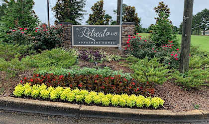 a sign for the relentless landscaping company in front of a garden