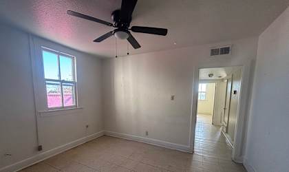 A room with a ceiling fan and a window.