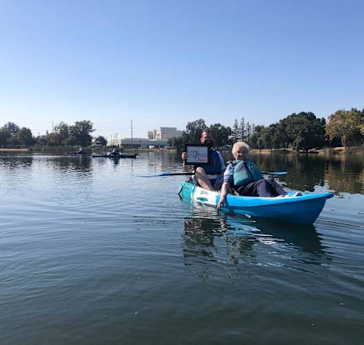 a woman is sitting in a kayak on a lake at Lodi Commons Senior Living, Lodi, 95240