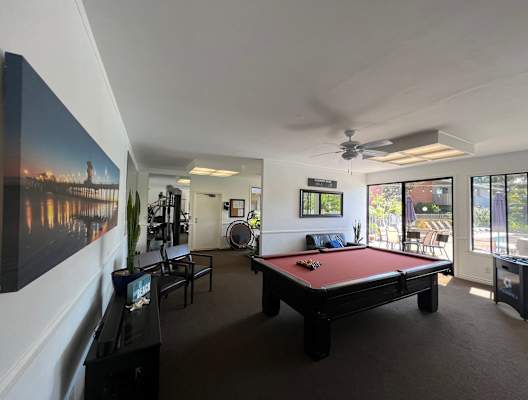 a pool table in a living room with a view of a river