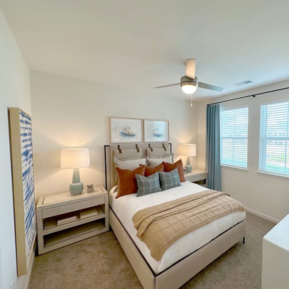 A bedroom with a large bed and a ceiling fan.