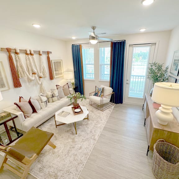 A living room with a white couch, a coffee table, and a rug.