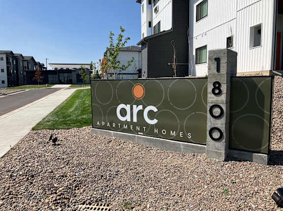 a sign that says arc apartment homes in front of a building
