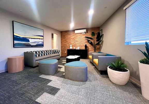 a lobby with couches and chairs and a tv