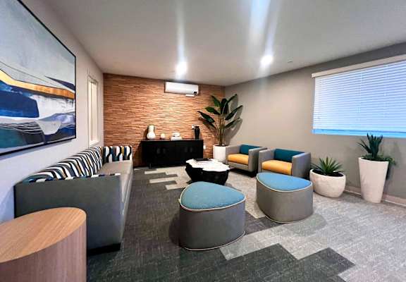 a lounge room with couches and chairs and a large window