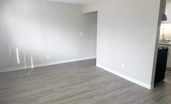 an empty living room with white walls and wood floors