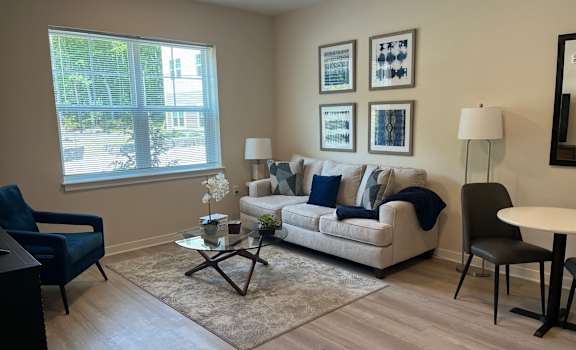 A living room with a couch, chair, and pictures on the wall.