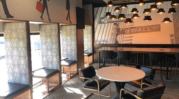 A conference room with a large table and chairs, a mural of people on the wall, and a banner at Park Michigan Apartments, Chicago, IL