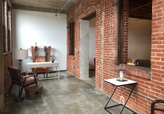 a living room with a brick wall and a table