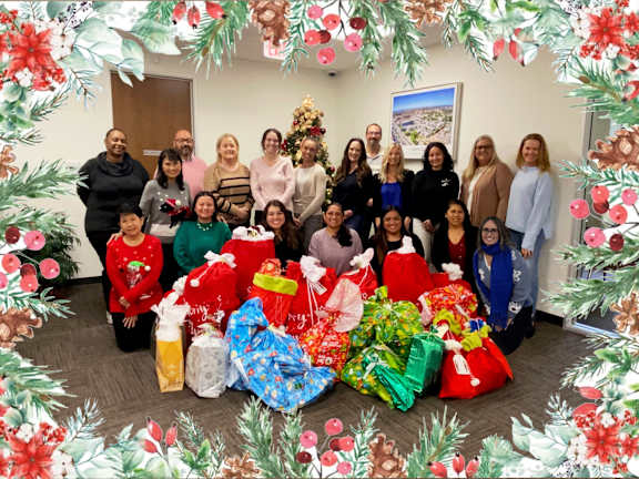 a group of people with christmas presents and a christmas tree