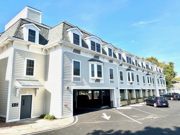 a large white building with a car garage in front of it