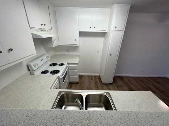 an empty kitchen with white cabinets and a stainless steel sink