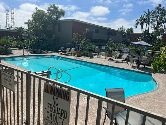 a warning sign on a fence in front of a swimming pool