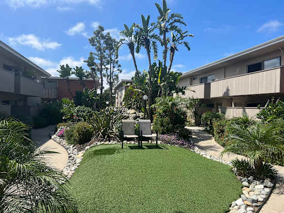 a small grassy area with a bench in front of a building