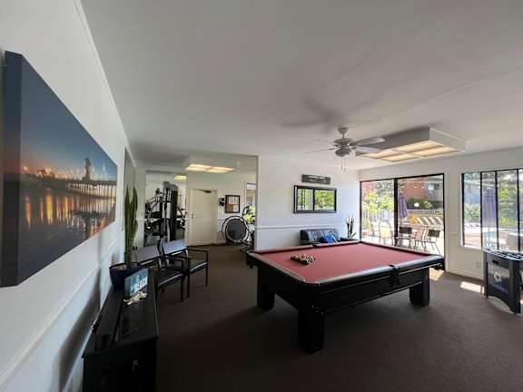 a pool table in a living room with a view of a river