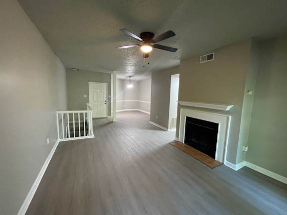 A room with a fireplace and a ceiling fan.