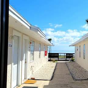 a view of the outside of a building with the ocean in the background