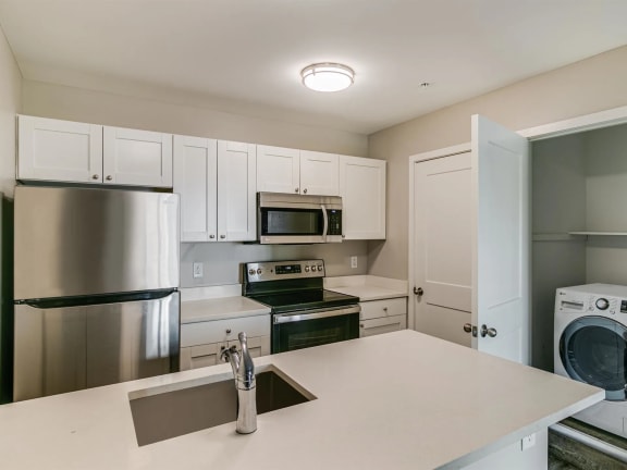 a kitchen with white cabinets and stainless steel appliances