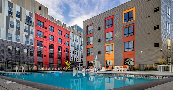 A modern apartment complex with a pool in the foreground.at Center Square Lofts East, Allentown, PA 18101