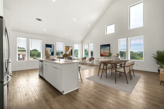 an open kitchen and dining area with a table and chairs and a large window
