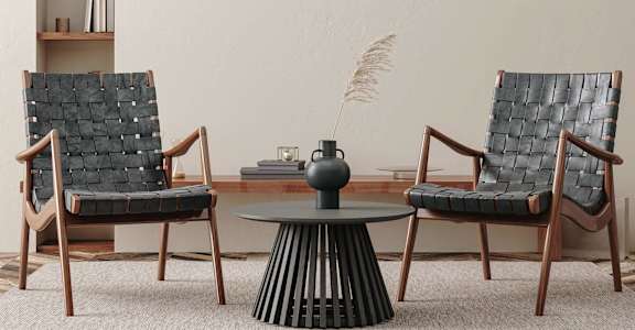 Two chairs and a table with a vase on it.