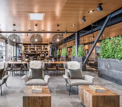 A modern living room with a wooden ceiling and grey chairs.