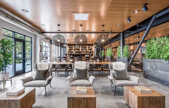 A modern living room with a wooden ceiling and grey chairs.