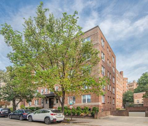 an apartment building on a city street with parked cars