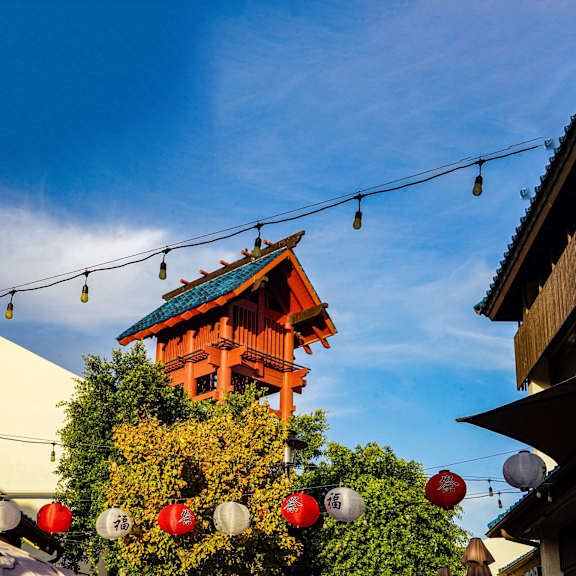 A traditional Japanese building with a red lantern hanging in front of it.