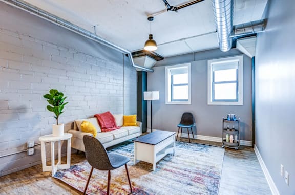 A living room with a white couch, a small table, and a rug.