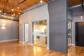 A room with a wooden floor and a glass wall with the word  at Montgomery Mill Apartments in Windsor Locks, CT