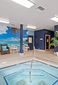 A large indoor swimming pool with a mural of a beach scene on the wall.