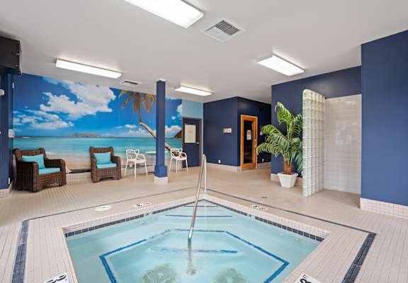 A large indoor swimming pool with a mural of a beach scene on the wall.