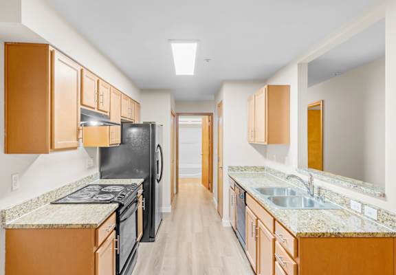 A kitchen with black appliances and wooden cabinets.