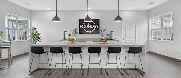 A kitchen with a bar area and a sign that says "FOUNDRY" hanging above it.