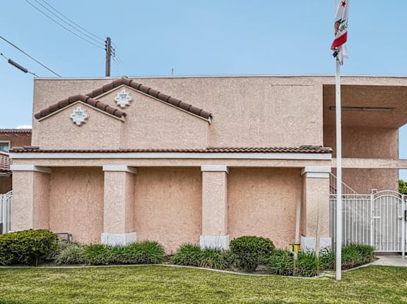 A building with a flag on top and a gate in front.