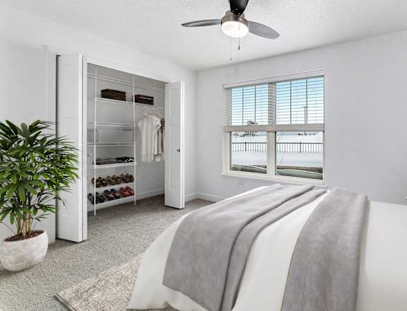 A bedroom with a large bed and a walk in closet at Eagle Ridge Apartment Homes in Traverse City, MI